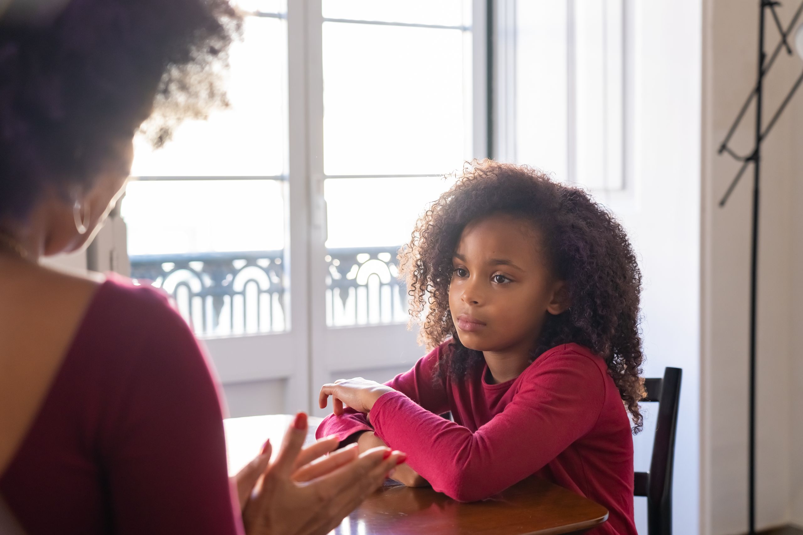 A mother talks to her daughter in a warm family setting, highlighting parenting dynamics.