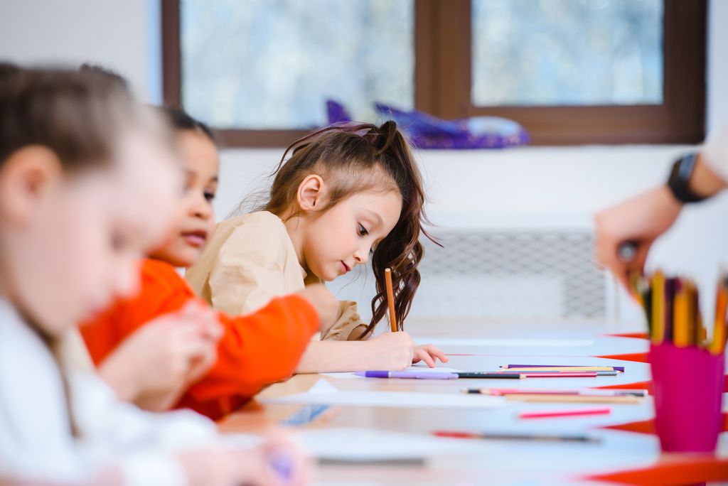 Children creatively engaged in an art class drawing and coloring with vibrant pens in school