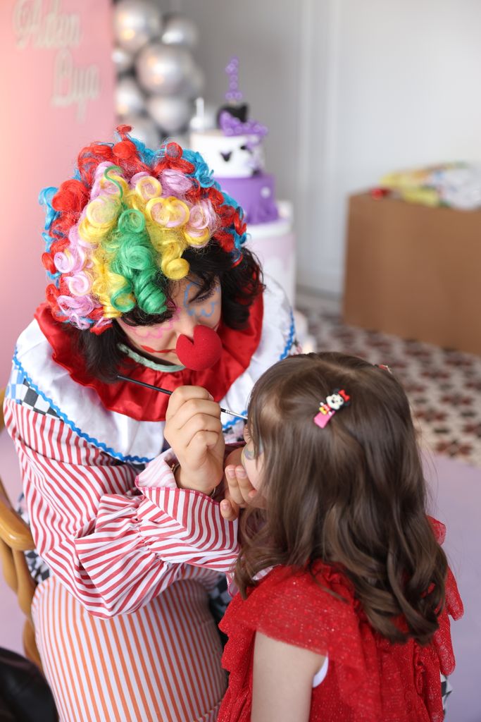 Clown face painting a girl at a lively children's party in Roanoke, va.
