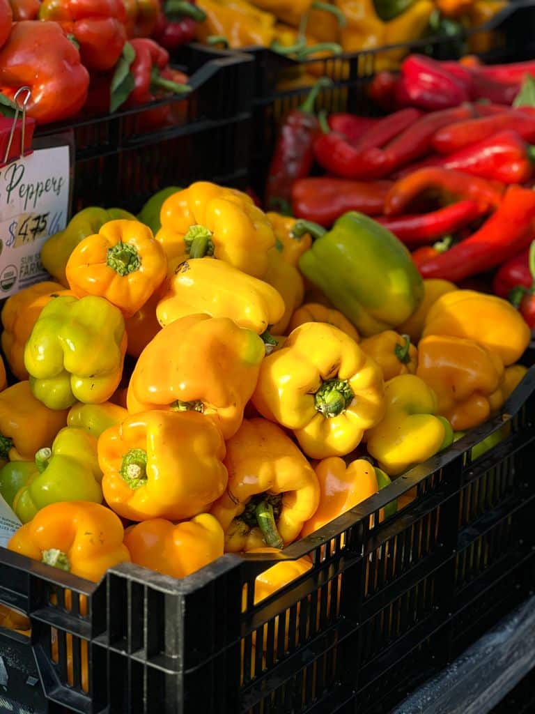 Colorful yellow and green bell peppers stacked in black crates at a farmer's market Roanoke, Va.