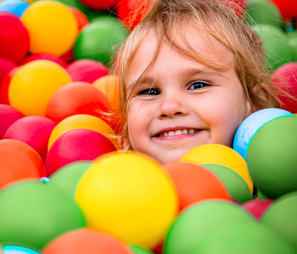 Smiling child having fun in a colorful ball pit, showcasing happiness and playtime Roanoke, Va.
