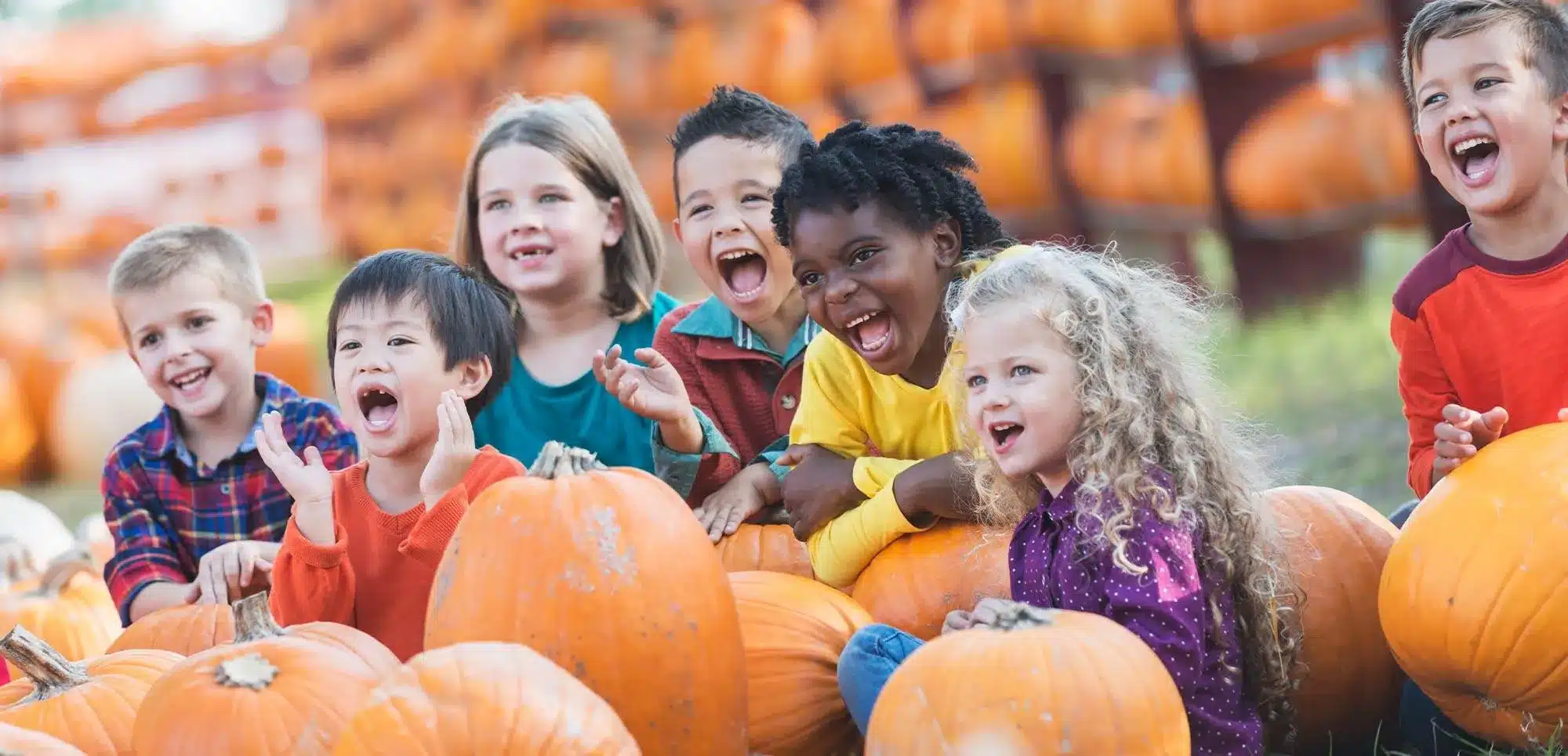 kids smiling in pumpkin patch